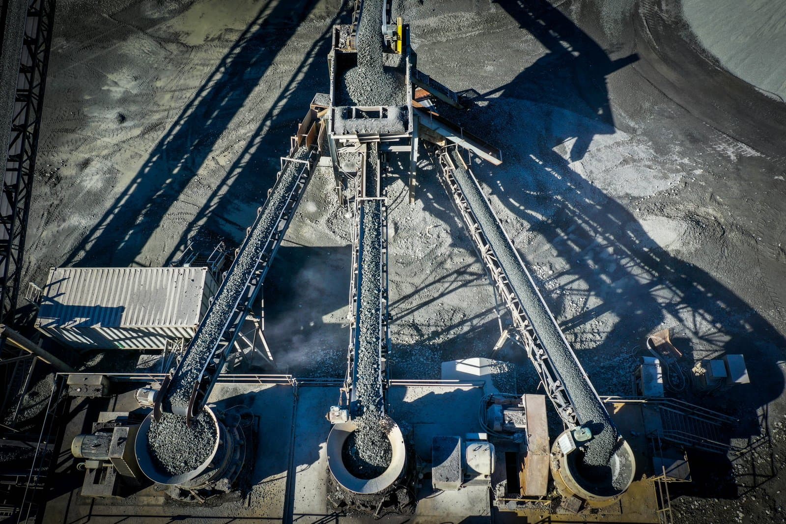 Crushing-plant conveyors stacking freshly graded aggregate into stockpiles.